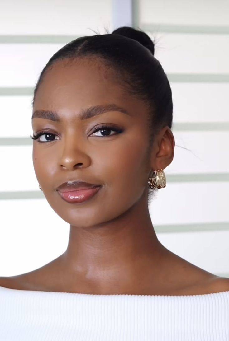 Polished makeup with defined lashes and a glossy rose-nude lip
