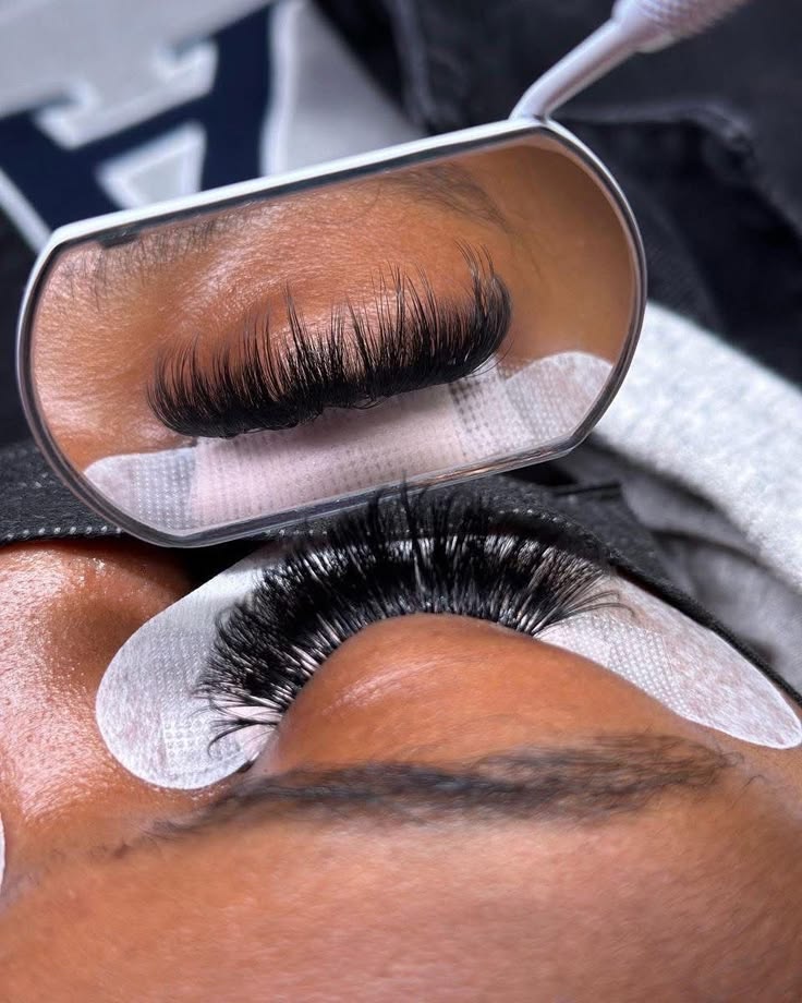 Full volume lash set shown in a hand mirror during the appointment